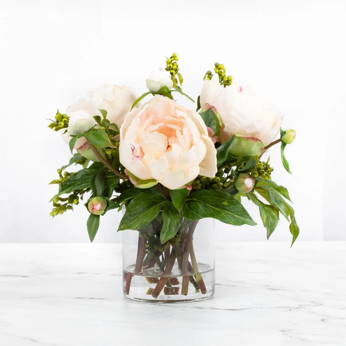 Composition de pivoines artificielles dans un vase en verre