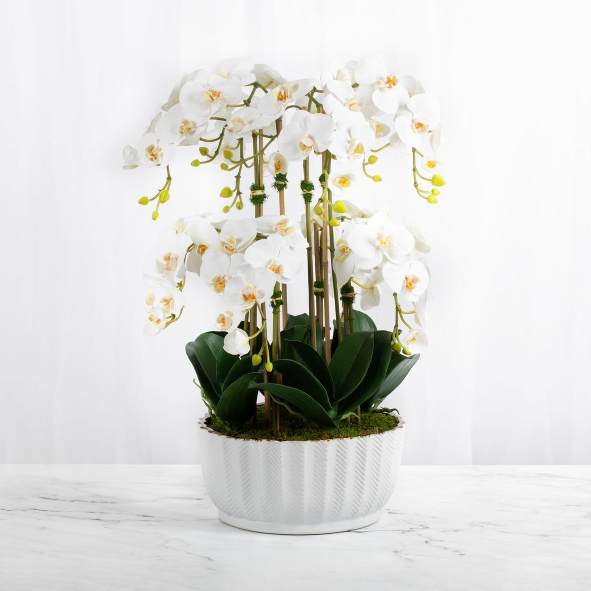Centrotavola con orchidea finta in vaso bianco
