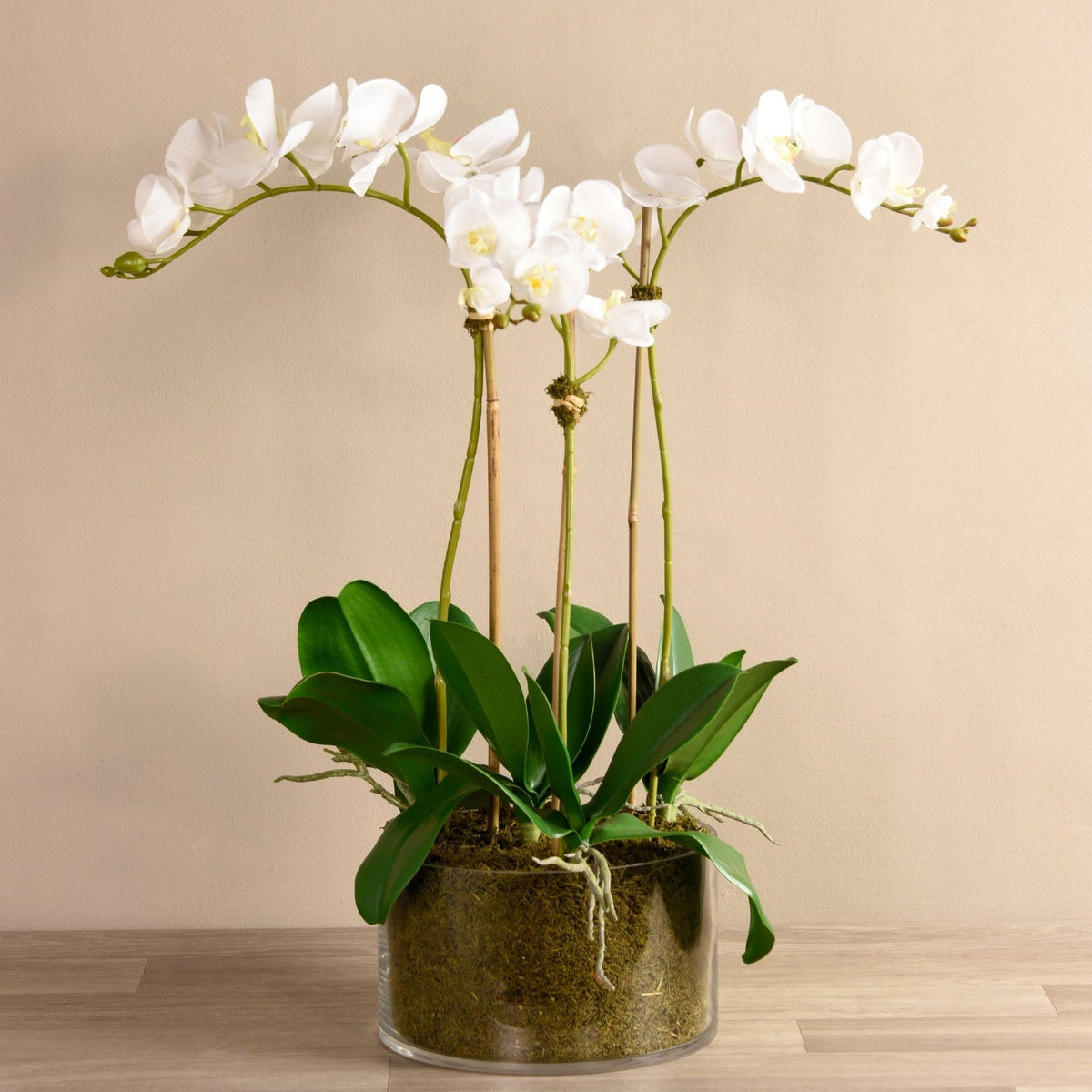 Large faux white orchid arrangement in glass vase